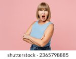 Small photo of Side view elderly sad blonde woman 50s years old she wears blue undershirt casual clothes look camera hold hands crossed folded scream isolated on plain pastel light pink background. Lifestyle concept
