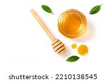 Small photo of Honey jar with honey dipper and leaves isolated on white background. Top view