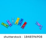 Small photo of Spring-type wooden clothespins deride or laugh fracture leg on blue background. Bullying, loneliness and depression concept. Copyspace for text