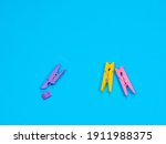 Small photo of Spring-type wooden violet clothespin with fracture leg on blue background. Bullying, loneliness and depression concept. Copyspace for text. Deride or laugh, mock