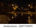 water reflections on charles bridge in Prague by night