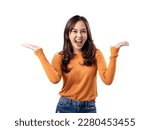 Small photo of A portrait of a happy Asian Indonesian woman wearing an orange sweater and looking confused with both hands to the side, isolated on a white background