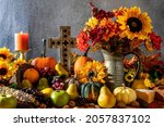 Small photo of Thanksgiving cornucopia with pumpkins fruit flowers and wooden cross