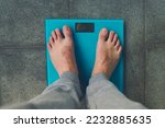 Small photo of Man standing on weight scale. Male feet on glass scales, men's diet, body weight, close up, man stepping up on scales, side view