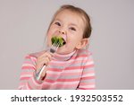 Small photo of The child eats broccoli with undisguised disgust. High quality photo
