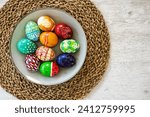 Small photo of Colorful Easter eggs hand-painted at home. Using food coloring to dye Easter eggs. Painting eggs with candle wax. Getting ready for Easter egg hunt. Family traditions.