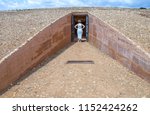 Small photo of Visitor woman getting into Dolmen de Soto. This is the most importat megalithic monuments in the province of Huelva, Spain