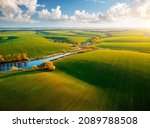 Small photo of Bird's eye view of abstraction agricultural area and green wavy fields in sunny day. Aerial photography, top view drone shot. Ukrainian agrarian region, Europe. Picturesque wallpaper. Beauty of earth.