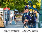 Small photo of EDINBURGH, UK - JUNE 11, 2022: Bagpiper playing music with bagpipe near Edinburgh Castle in Edinburgh, Scotland, UK