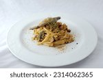 Small photo of Italian Traditional Dish"Spaghetti con le sarde",spaghetti,sardine,raisins,wild fennel,olive oil,breadcrumbs,pine nuts,onions,anchovy,saffron,salt and peppers on plate with white table background