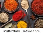 Various spices in bowls and spoons on dark stone table. Indian cuisine. Top view flat lay