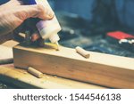 Small photo of wood dowel joint - joiner put the glue into a drilled wooden hole