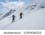 Ski touring couple hiking up a summit in the alps