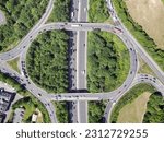 Aerial high drone in 4K flight over road traffic. Highway and overpass with cars and trucks, interchange, two-level road junction in the big city. Top view. 