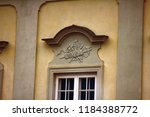 Small photo of Ancient bas-reliefs on the Windows and walls of historical buildings. Architectural design elements from the past. Warsawa. Ax, poleaxe on the crown of the window