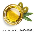 Bowl of fresh extra virgin olive oil and green olives with leaves isolated on white background. Top view