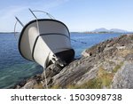 Small photo of Close up photo of recreational boat after collision with rocks. Vacation trip gone awry. Photographed at Norwegian coast, Scandinavia.