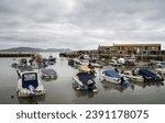Small photo of LYME REGIS, DORSET, UK - MAY 7 2023: View of the Cobb and harbour with boats and tide in.