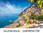 Aerial view of Positano with comfortable beach and blue sea on Amalfi Coast in Campania, Italy. Amalfi coast is popular travel and holyday destination in Europe. Ripe yellow lemons in foreground.