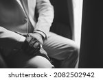 Small photo of A man in a suit with a signet ring on his little finger sits by the window, close-up, black and white