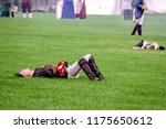 Small photo of WHEATON, IL/USA - SEPT. 8, 2018: A fallen young soldier appears to have suffered a mortal wound on a mock battlefield at a public reenactment of the American Revolutionary War (1775-1783).
