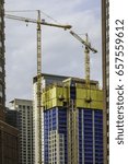 Small photo of CHICAGO, ILLINOIS/USA - JUNE 8, 2017: Two construction cranes highlight the continual upgrowth of downtown Chicago, where the first steel-frame skyscraper was built in 1885.