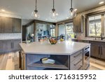 Small photo of Absolutly stunning kitchen interior with grey tone of brown muted natural tones with light hardwood and rustic modern island with colorful plates.