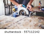 Small photo of Carpenter using circular saw for cutting wooden boards. Construction details of male worker or handy man with power tools