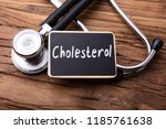 Cholesterol Word Written On Slate With Stethoscope On Wooden Table