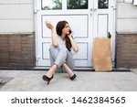 Small photo of An Afraid Young Woman Sitting Outside The Door Talking On Mobilephone