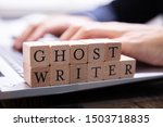 Small photo of Ghostwriter Wooden Block On Computer Keyboard While Someone Typing