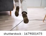 Small photo of Close-up Of A Man Legs Stumbling With An Electrical Cord At Home