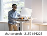 Man Using Adjustable Height Standing Desk In Office For Good Posture