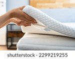 Small photo of Mattress Topper Being Laid On Top Of The Bed