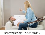 Female Psychiatrist Hypnotizing Patient Lying On Couch
