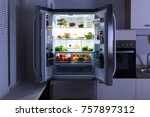 Open Refrigerator Full Of Juice And Fresh Vegetables In Kitchen