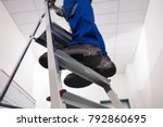 Close-up Of Man Standing On Steel Ladder