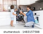 Father and son loading dishwasher together