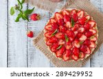 Tart with strawberries and whipped cream decorated with mint leaves. Top view