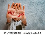 slogan of peace without war is written on the child's hand in red no war. The concept of No war, stop the war, peace
