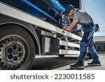 Small photo of Tow Truck Driver Preparing to Safely Deliver Brand New Car From Dealer to Buyer. Vehicle Transportation Theme.