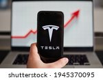 Small photo of Tesla logo on a smartphone and the chart covering the last month with Tesla company stocks price. Graph. Medias, Romania 29.03.2021