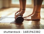 Small photo of Close up of a womans hands is rolling up exercise mat and preparing to doing yoga. She is exercising on floor mat in morning sunshine at home.