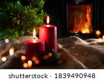 Christmas decorations with log fire and festive bokeh. Atmospheric christmas still life with fir tree and with candlelight on rustic linen sack. Space for your text. 