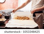 Chef wraps the filling into dough, apple strudel