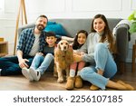 Small photo of Portrait of happy relaxed parents and young children relaxing in the living room together with their beautiful cocker spaniel dog