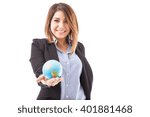 Small photo of Portrait of a cute and happy female travel agent holding a small globe in her hand and smiling
