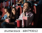 Small photo of Profile view of a very obnoxious and disrespectful man talking on the phone while sitting in a movie theater