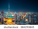 Fantastic nighttime skyline with illuminated skyscrapers. Rooftop perspective of downtown Dubai, UAE. 