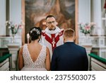 Couple standing before the priest for wedding ceremony in church. Bride and groom standing in the presence of priest during their wedding ceremony